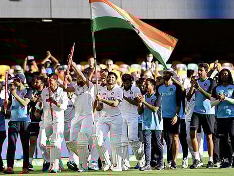 Indian players celebrate after defeating Australia by three wickets on the final day of the fourth cricket test match at the Gabba, Brisbane.
