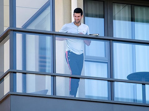 World No.1 Novak Djokovic stands on the balcony at his accommodation during the quarantine period in Adelaide.