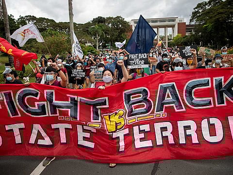 Students and activists march to protest following the defense ministry's cancellation of a decades-long pact hindering police and soldiers from University of the Philippines.