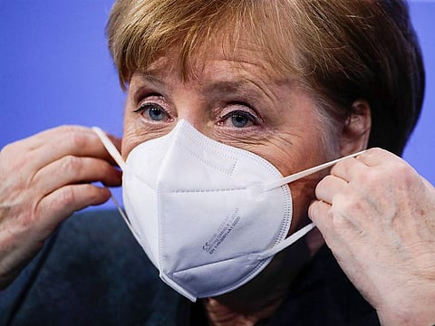 German Chancellor Angela Merkel puts on a face mask after a press conference following talks via video conference with Germany's state premiers on the extension of the current lockdown due to the coronavirus COVID-19 pandemic, at the Chancellery in Berlin on January 19, 2021.