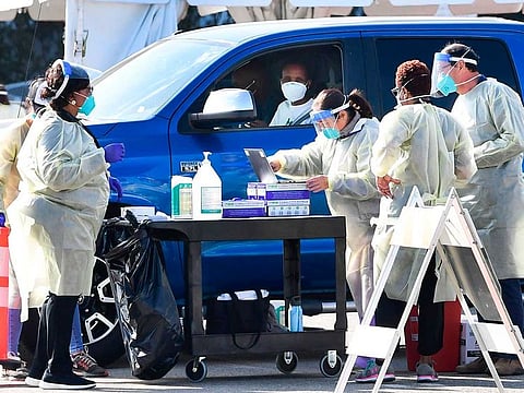 People pull up in their vehicles for COVID-19 vaccines in the parking lot of The Forum in Inglewood, California on January 19, 2021. Five large-scale vaccination sites opened throughout Los Angeles County in the fight against the coronavirus pandemic as California became the first state to top 3 million virus cases.