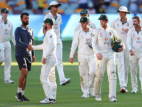 India's Cheteshwar Pujara, second left, is congratulated by Australia's Matthew Wade on the final day of the fourth Test at the Gabba, Brisbane.