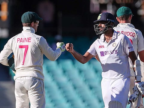 India's Ravichandran Ashwin (right) fist-bumping with Australia's captain Tim Paine at the end of the third cricket Test in Sydney on January 11, 2021. Paine apologised to Ashwin the next day for launching an ugly tirade, admitting he was "bitterly disappointed" in his own conduct.