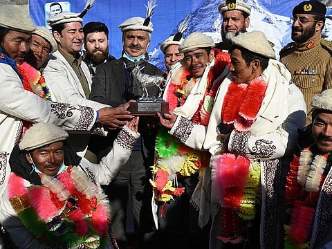 Nepal's climbers receive a souvenir while attending a welcome ceremony upon their arrival after becoming the first to summit Pakistan's K2 in winter, at Shigar district in the Gilgit-Baltistan region of northern Pakistan on January 20, 2021.