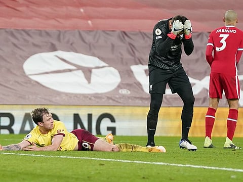 Liverpool goalkeeper Alisson Becker is in despair after he fouled Ashley Barnes (on the ground) of Burnley inside the penalty box during their Premier League match on Wednesday. Barnes converted from the spot to hand Liverpool their first home defeat after 68 games.
