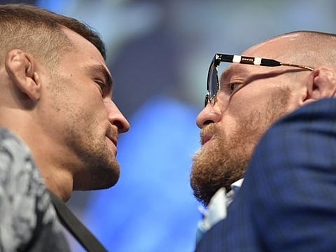 Striking a pose: Conor McGregor (right) and Dustin Poirier on their arrival for the weigh-in on Friday.