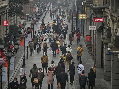 People walk along a pedestrian street in Wuhan, China's central Hubei province on January 23, 2021, one year after the city went into lockdown to curb the spread of coronavirus.