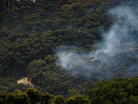 Emergency services can be seen fighting a bushfire that is burning in the Cherry Gardens area in the Adelaide Hills, Australia, January 25, 2021.