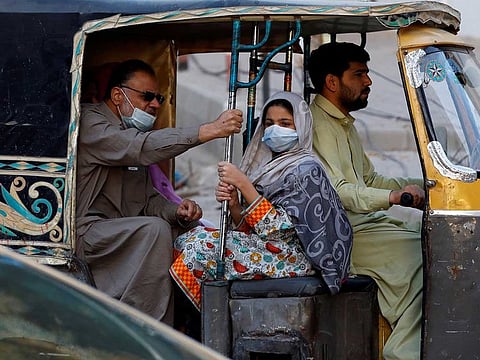 People with masks to fight against COVID-19 travel by rickshaw in Karachi, Pakistan January 25, 2021.
