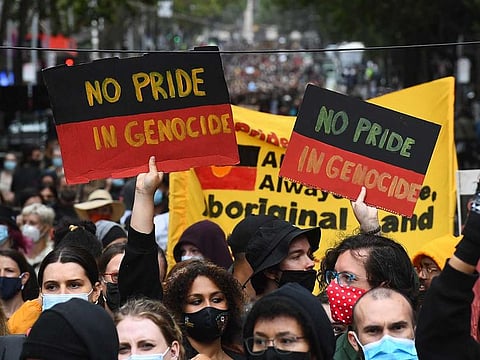 People carry placards as thousands of people attend an Australia Day protest in Melbourne in January 26, 2021.