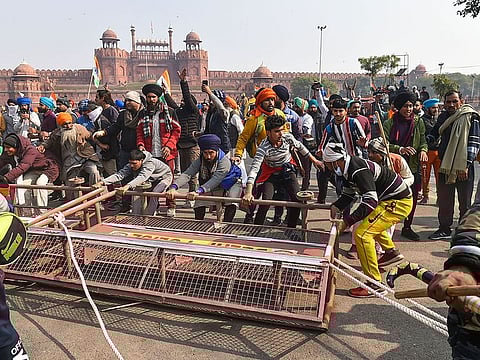 Farmers remove police barricades set up near the Red Fort during the 'Kisan Gantantra Parade' amid the 72nd Republic Day celebrations, in New Delhi, Tuesday, Jan. 26, 2021.