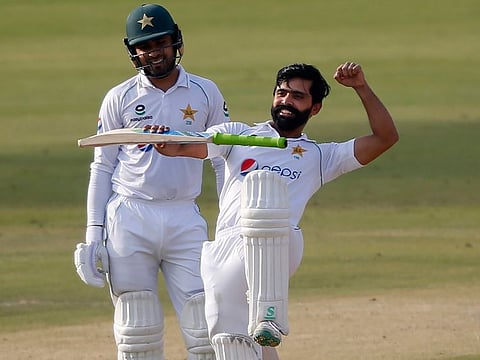Pakistan's Fawad Alam (right) celebrates with a traditional dance move after scoring a century while his teammate Faheem Ashraf looks on during the second day of their first Test at National Stadium in Karachi on Wednesday.
