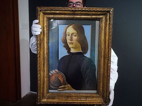 A worker at Sotheby's Auctions poses with Sandro Botticelli's "Young Man Holding a Roundel" during a preview where it is expected to fetch in excess of $80 million USD in the Manhattan borough of New York City, New York, US, January 22, 2021.