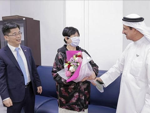 On January 29, 2020, Liu Yujia, a 73-year-old grandma visiting from China, was the first in a family of four to have been diagnosed with COVID-19 in the UAE. The picture shows her with Consul General of China Li Xuhang and Dr Hussein Al Rand, Assistant Under-Secretary at the UAE Ministry of Health and Prevention, after she recovered.