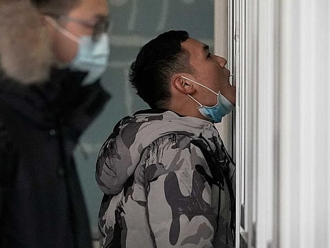 A man gets a swab for the coronavirus test at a hospital in Beijing.