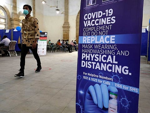 A man walks past an awarness sign inside the Khaliq Dina Hall and Library, which has been converted to be used as a vaccination centre, to administering coronavirus disease (COVID-19) vaccine, in Karachi, Pakistan.