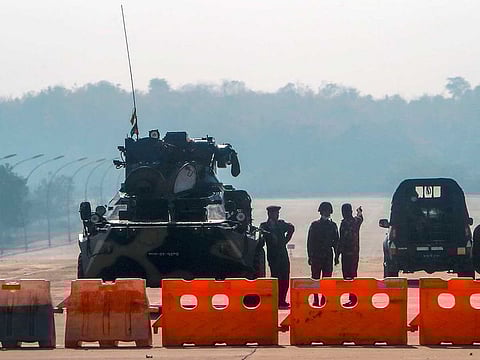 Myanmar's military stand guard at a checkpoint manned with an armored vehicle in a road leading to the parliament building Tuesday, Feb. 2, 2021, in Naypyitaw, Myanmar.