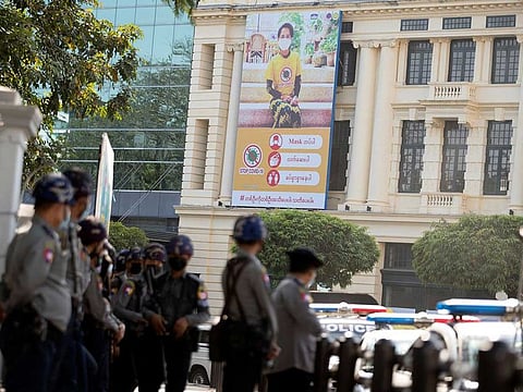 A COVID-19 poster with Aung San Suu Kyi's portrait is seen as police wait for protests against the coup in Yangon, Myanmar February 4, 2021.