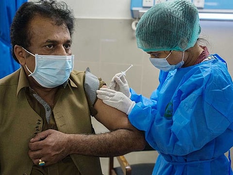 A health worker administers a COVID-19 vaccine to a colleague at the Dow University Hospital in Karachi, Pakistan.