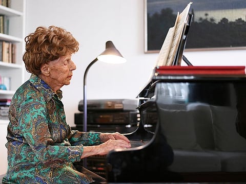 Pianist Colette Maze, plays piano as she poses at her home in Paris.