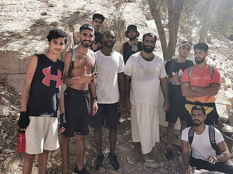 The stranded Emiratis with RAK Civil Defence employee Youssef Al Habsi after he rescued them from Wadi Naqab in Ras Al Khaimah on Saturday.