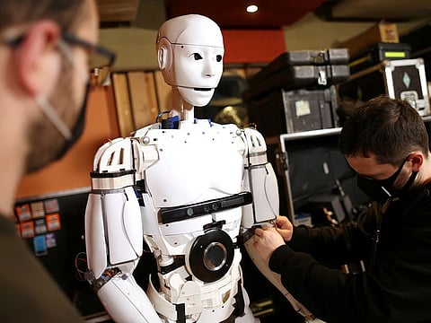 Almir Besic (L), former student of the Electrical Engineering Faculty and Vedran Mujagic, member of rock group 'Dubioza Kolektiv' fix humanoid robot called 'Robby Megabyte' in Sarajevo.
