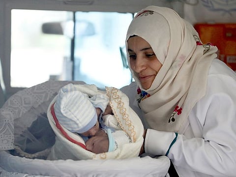 A nurse holds conjoined twins Muhammad and Ahmad Yasser Al Bukhaiti inside an ambulance at Sanaa airport as they wait to be airlifted for a separation surgery in Jordan.