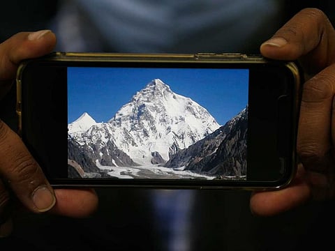 A photo of K2, the world's second-highest mountain, is displayed on a cell phone in Islamabad, Pakistan, Tuesday, Feb. 9, 2021.