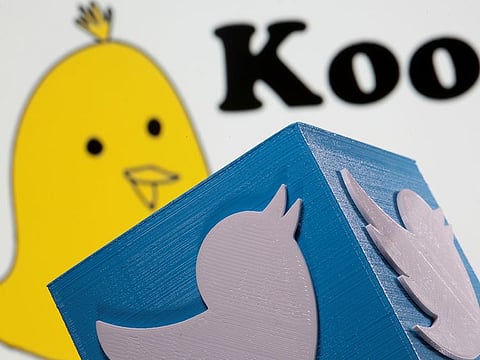 A 3d printed Twitter logo is seen in front of displayed Koo app logo in this illustration.