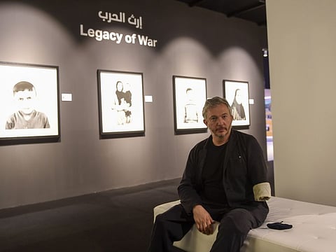 Giles Duley, documentary photographer and writer, with his work at Xposure 2021, at Sharjah Expo Centre, on Wednesday.