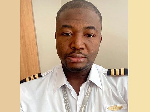Babatunde Lawal Isiaka in a pilot's uniform, wearing a laynard neck strap with Emirates airlines’ name