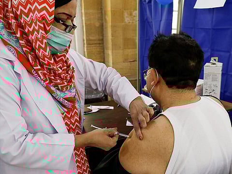 A health worker receives a dose of Sinopharm's COVID-19 vaccine at a vaccination centre in Karachi.