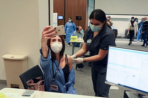 A woman takes a picture with her mobile phone as she receives the Pfizer/BioNTech vaccine against the COVID-19 during a coronavirus vaccination campaign at American University of Beirut's (AUB) medical centre on February 14.