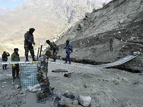 Army personnel build a bridge near Raini village, in the aftermath of a glacier burst in Uttarakhand's Joshimath that triggered a flash flood in Chamoli district, Sunday, Feb. 14, 2021.