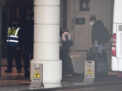Passengers disembark from a coach to enter a Radisson Blu hotel at Heathrow Airport where they will undertake mandatory hotel quarantine in west London on February 15, 2021.