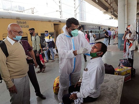 A health worker takes a swab sample of a commuter to test for COVID-19 at a train station in Mumbai, India. A consignment of 120 oxygen concentrators from the UK reached India this morning.