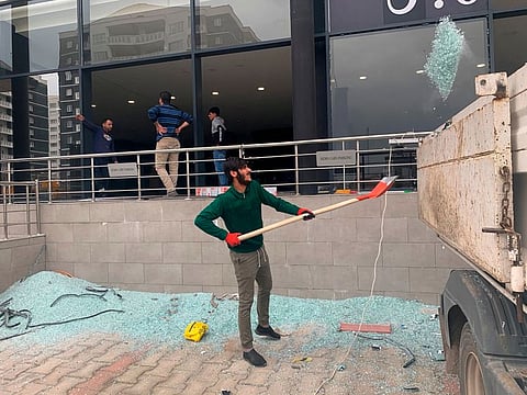 Workers clean the aftermath of rockets attack in Erbil. Rockets struck outside an airport near where US forces are based in northern Iraq on Feb. 16, 2021.