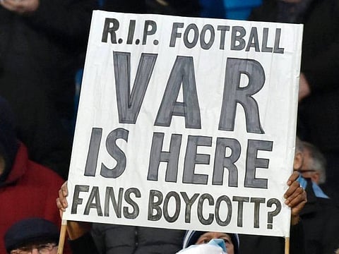 Fans hold up signs protesting against VAR, also known as video assistant referee.