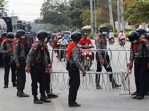 Police security forces place a barricade with razor wire in the middle of the road in Mandalay, Myanmar Friday, Feb. 19, 2021.