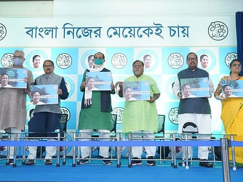 Senior leaders of All India Trinamool Congress display the placard with their election slogan which means, 'Bengal want their own daughter only.'