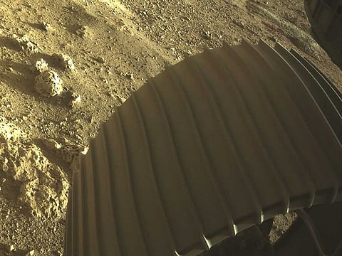 One of the six wheels aboard Nasa's Perseverance Mars rover is seen in a high-resolution, colour image sent back by the Hazard Cameras (Hazcams) on the underside of Nasa's Perseverance Mars rover after its landing on Mars February 18, 2021.