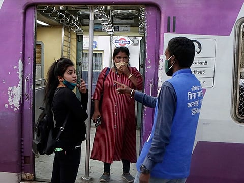 A municipal worker gives a commuter a penalty for not using a face mask at Chhatrapati Shivaji Maharaj Terminus in Mumbai, on February 20, 2021. AP