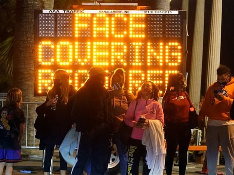 A sign encourages visitors to wear face masks amid the COVID-19 pandemic, in Santa Monica, California.