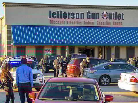 Bystanders react at the scene of a multiple fatality shooting at the Jefferson Gun Outlet in Metairie.