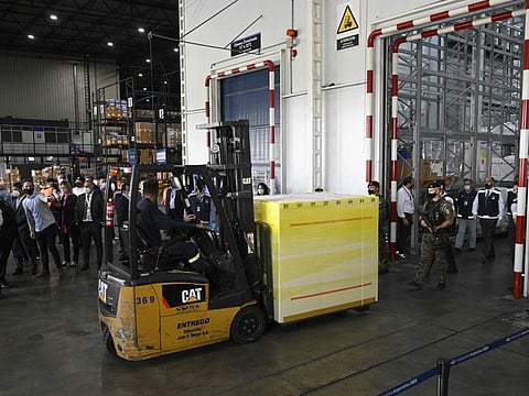 A worker moves a shipping container carrying doses of Covishield, the Indian-made Oxford/AstraZeneca vaccine against COVID-19, at Ezeiza International Airport in Buenos Aires, on February 17, 2021.