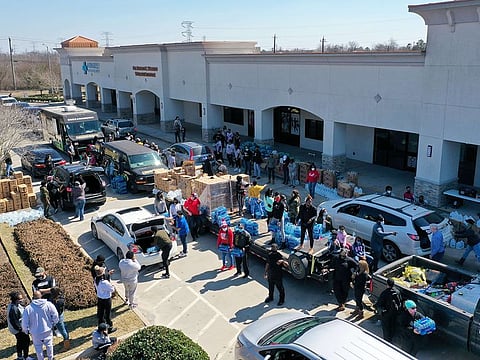 Volunteers pass out water during a water distribution event at the Fountain Life Center in Houston, Texas.
