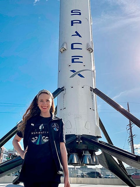Hayley Arceneaux stands near a SpaceX rocket at the aerospace company's headquarters in Hawthorne, California..