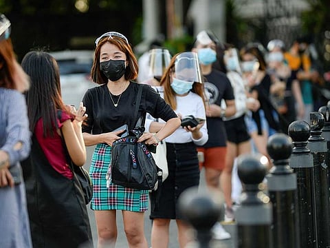 People wearing face masks and face shields as protection from the coronavirus disease (COVID-19) queue outside a newly reopened historical site, in Manila, Philippines.
