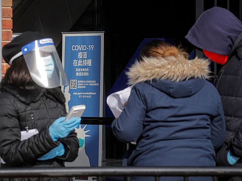 A health care worker helps people check-in for appointments to receive the coronavirus disease (COVID-19) vaccine outside Citi Field, the home stadium of MLB's New York Mets, during the coronavirus disease pandemic in the Queens borough of New York City, New York, U.S., February 10, 2021.