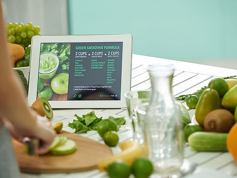 A woman follows a virtual recipe for a smoothie